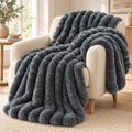 Plaid texturé gris Cocooning 180 × 200 cm sur un fauteuil — mise en scène illustrative