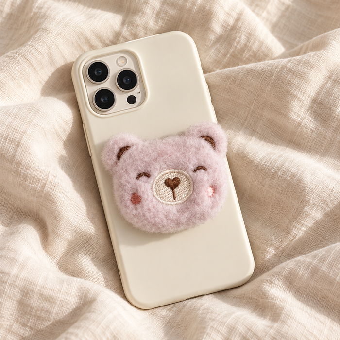 Support de téléphone en peluche ours rose sur une coque crème — Cocooning